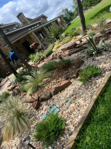 Luxury landscape design featuring layered stone terracing, drought-resistant plants, and modern residential architecture in Fort Worth