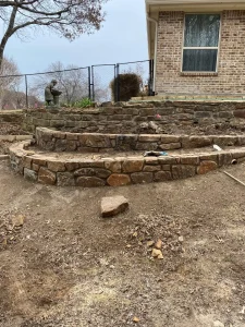 Multi-tiered stone retaining walls for luxury backyard transformation and outdoor living space in Fort Worth