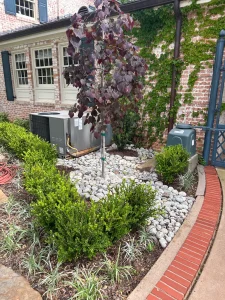 Modern luxury landscape design featuring white stone hardscaping and manicured shrubs